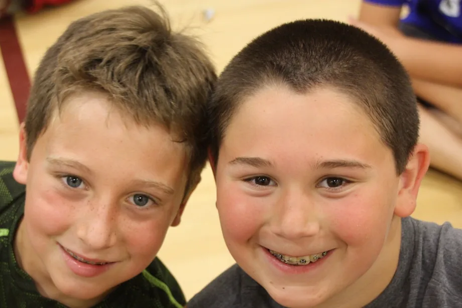 Two smiling campers lean in together for a photo