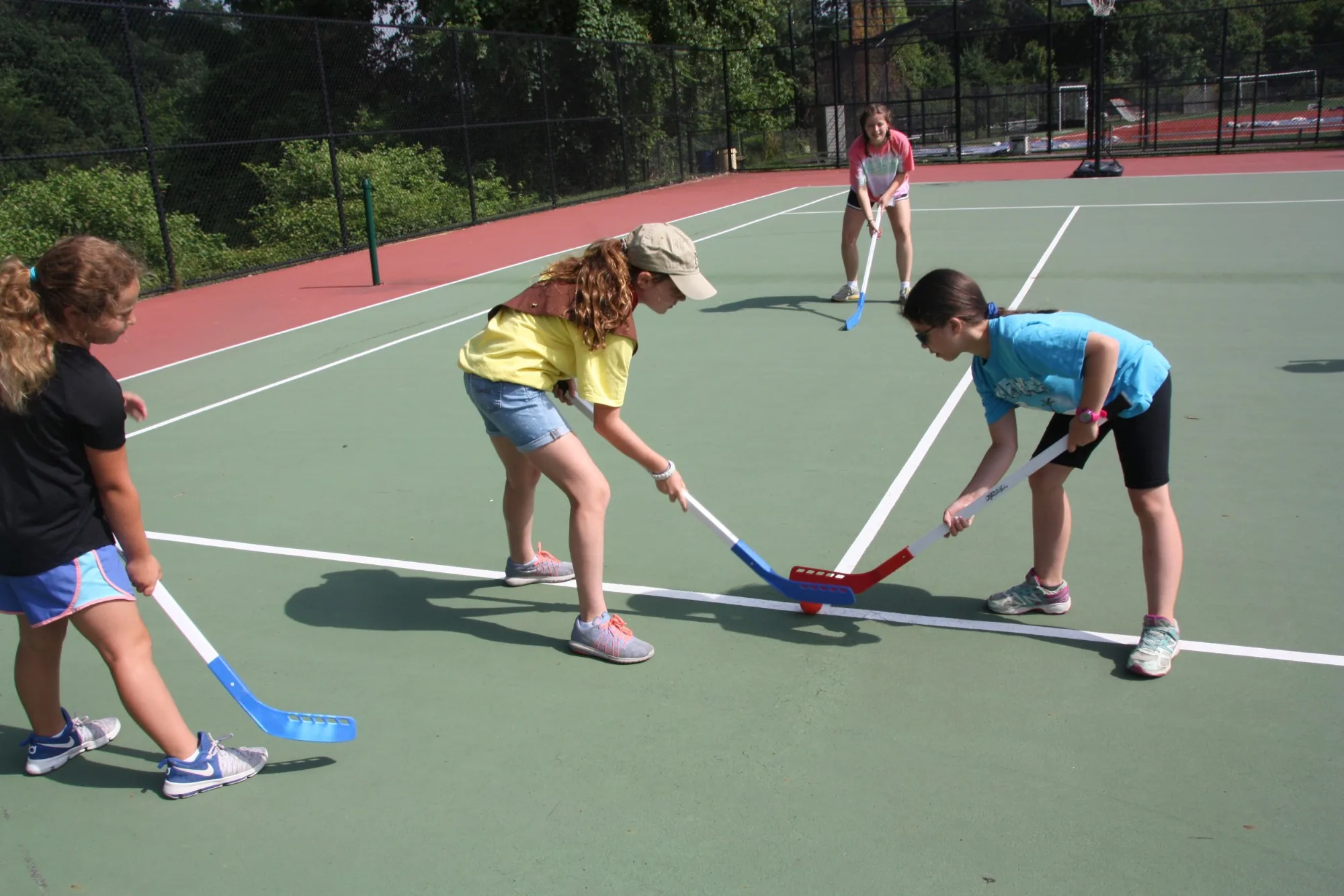 Campers face off in a game of floor hockey on an outdoor court